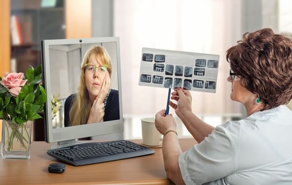 Dentist examining woman during online video session.